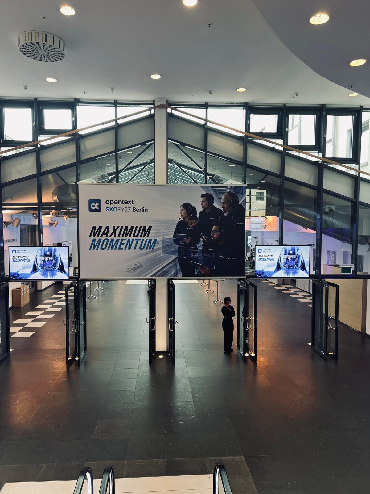 Acceso y cartelería Maximum Momentum del OpenText Sales Kickoff FY27 en Berlín